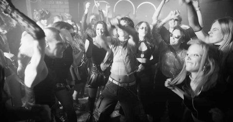 Crowd dancing together under stark monochrome club lighting